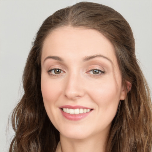 Joyful white young-adult female with long  brown hair and green eyes