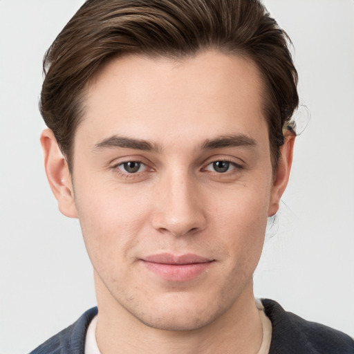 Joyful white young-adult male with short  brown hair and grey eyes