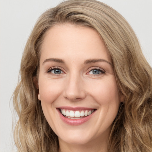 Joyful white young-adult female with long  brown hair and green eyes