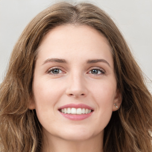 Joyful white young-adult female with long  brown hair and green eyes