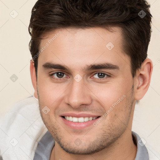 Joyful white young-adult male with short  brown hair and brown eyes