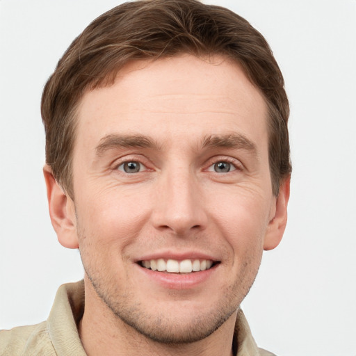 Joyful white young-adult male with short  brown hair and grey eyes