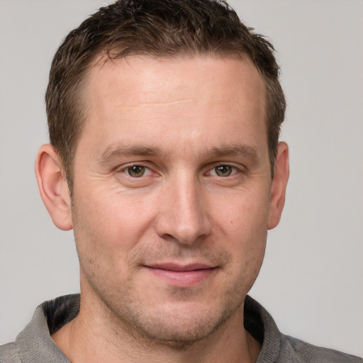 Joyful white adult male with short  brown hair and grey eyes