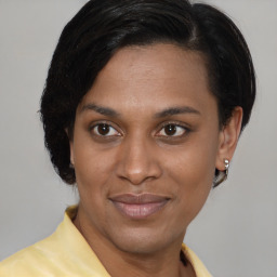 Joyful black adult female with medium  brown hair and brown eyes