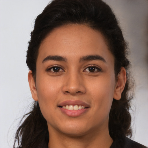 Joyful latino young-adult female with long  brown hair and brown eyes