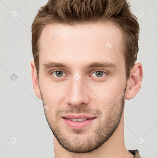 Joyful white young-adult male with short  brown hair and grey eyes