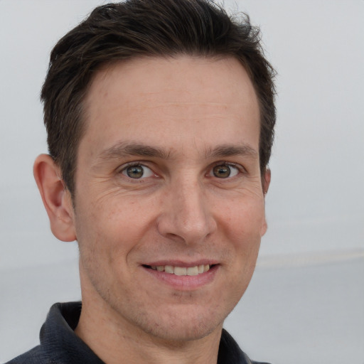 Joyful white adult male with short  brown hair and grey eyes