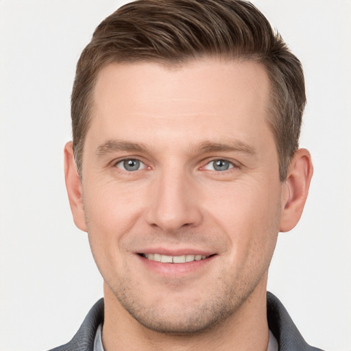 Joyful white young-adult male with short  brown hair and grey eyes