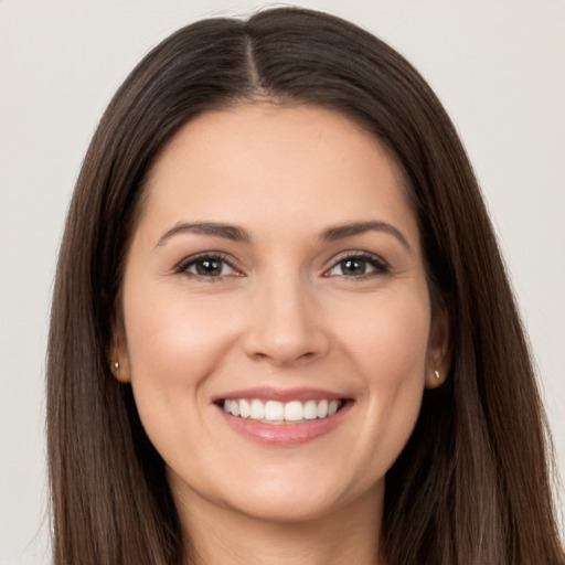 Joyful white young-adult female with long  brown hair and brown eyes