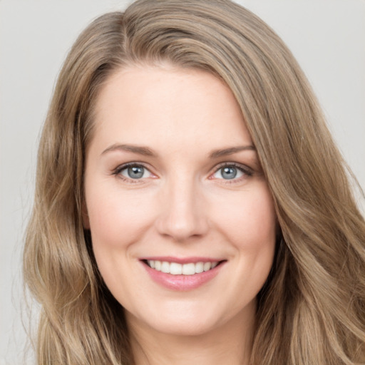 Joyful white young-adult female with long  brown hair and green eyes