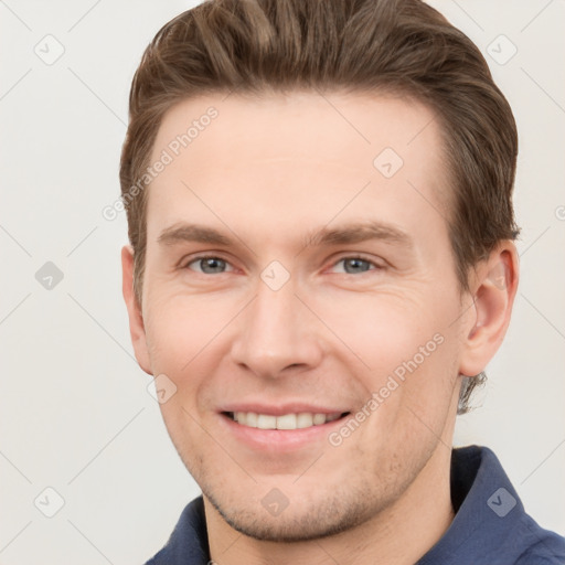 Joyful white young-adult male with short  brown hair and grey eyes