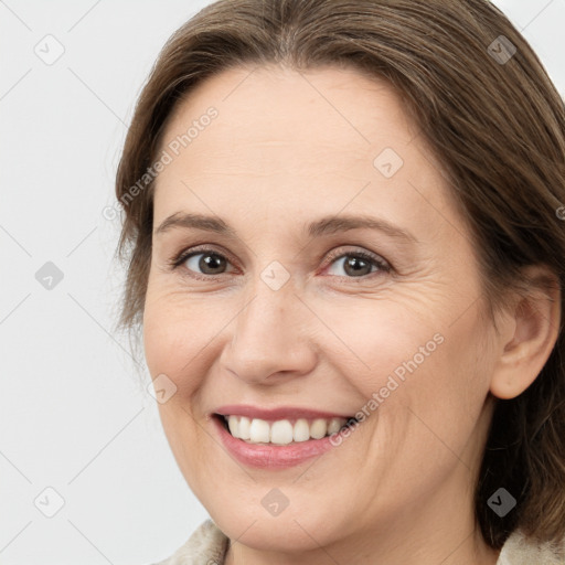 Joyful white adult female with medium  brown hair and grey eyes