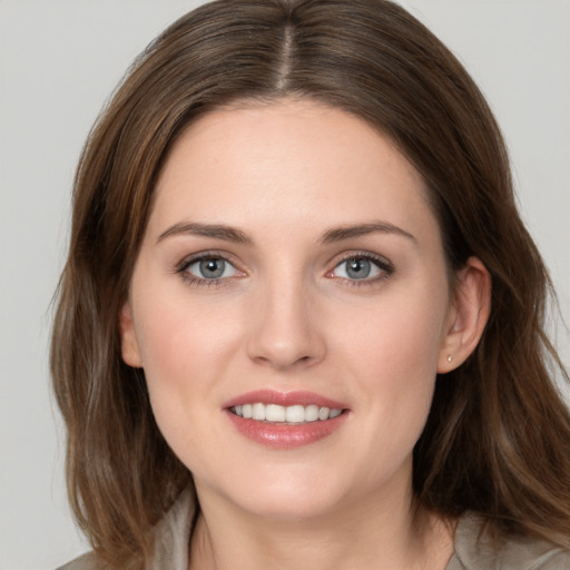 Joyful white young-adult female with medium  brown hair and grey eyes