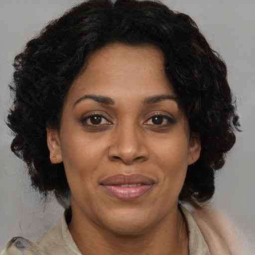 Joyful black adult female with long  black hair and brown eyes