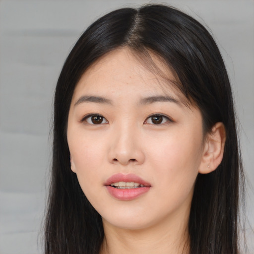 Joyful asian young-adult female with long  brown hair and brown eyes
