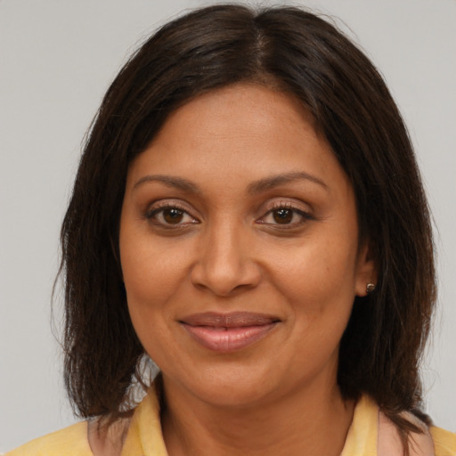 Joyful black adult female with medium  brown hair and brown eyes