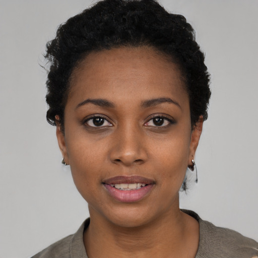 Joyful black young-adult female with short  black hair and brown eyes