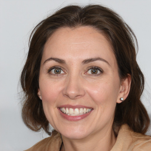 Joyful white adult female with medium  brown hair and brown eyes