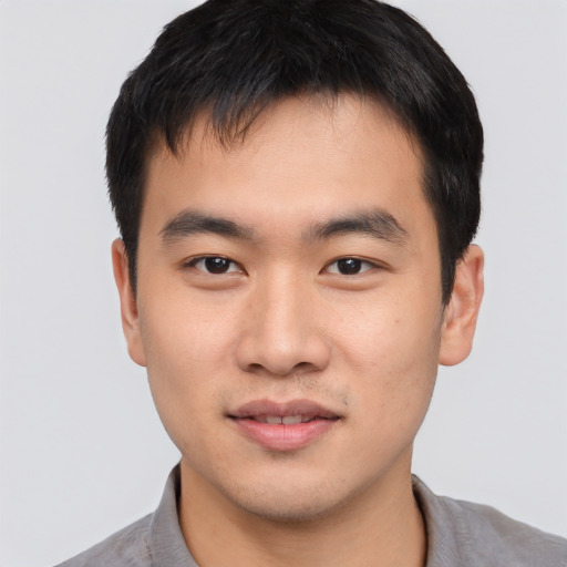 Joyful asian young-adult male with short  brown hair and brown eyes