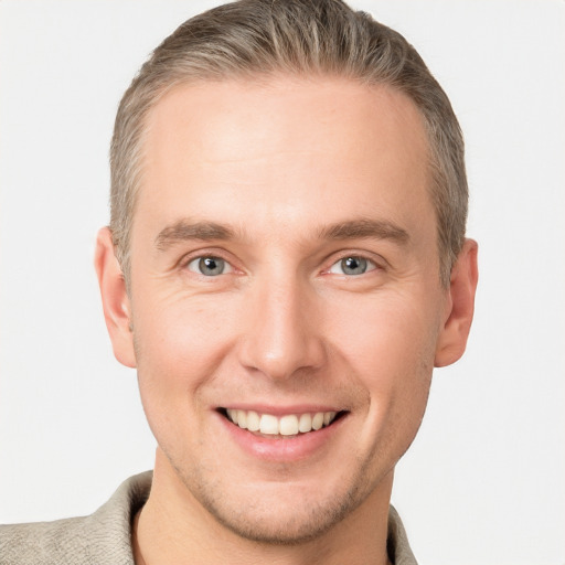 Joyful white young-adult male with short  brown hair and grey eyes