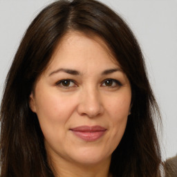 Joyful white adult female with long  brown hair and brown eyes