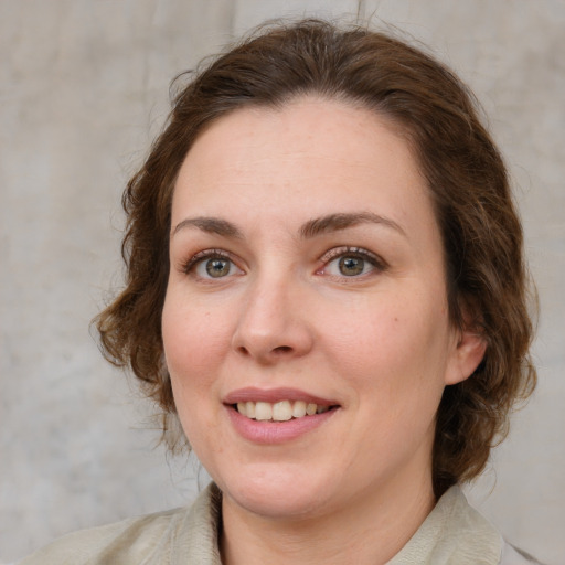 Joyful white young-adult female with medium  brown hair and green eyes