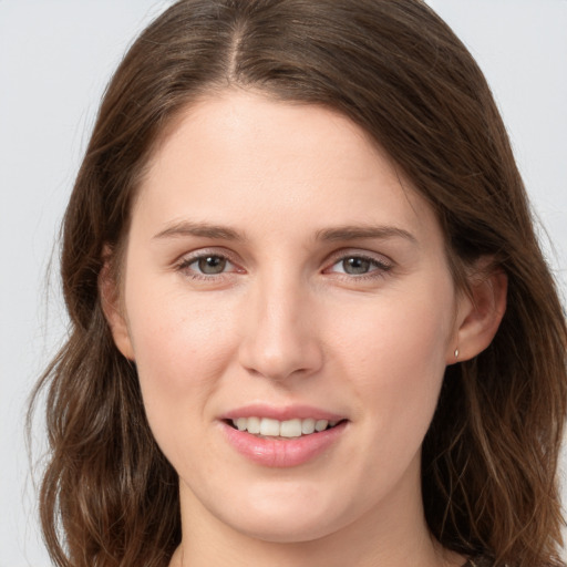 Joyful white young-adult female with long  brown hair and grey eyes