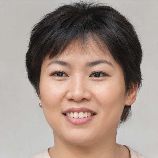 Joyful asian young-adult female with short  brown hair and brown eyes