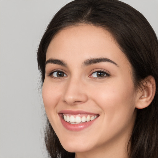 Joyful white young-adult female with long  brown hair and brown eyes