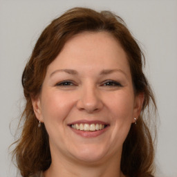 Joyful white adult female with medium  brown hair and grey eyes