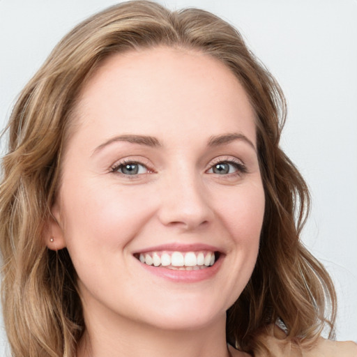 Joyful white young-adult female with long  brown hair and blue eyes