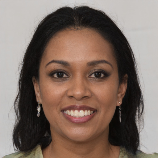 Joyful black young-adult female with long  brown hair and brown eyes