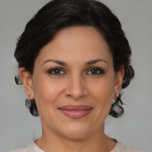 Joyful latino adult female with medium  brown hair and brown eyes