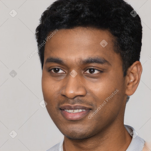 Joyful black young-adult male with short  black hair and brown eyes