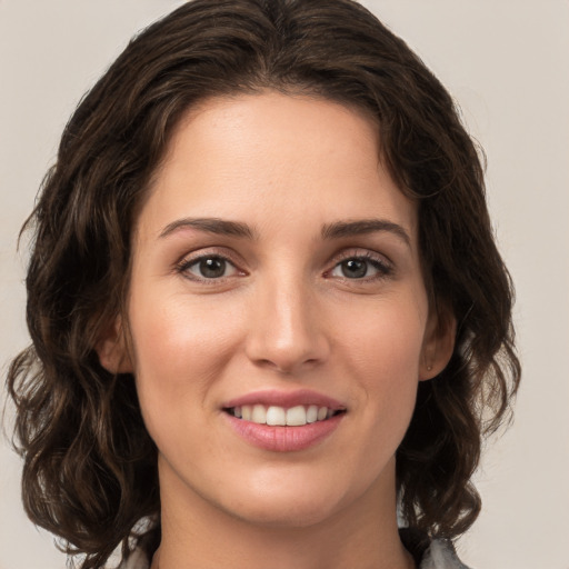 Joyful white young-adult female with medium  brown hair and green eyes