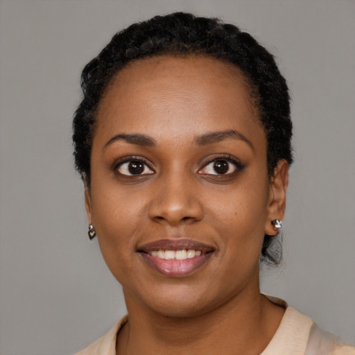 Joyful black young-adult female with short  black hair and brown eyes