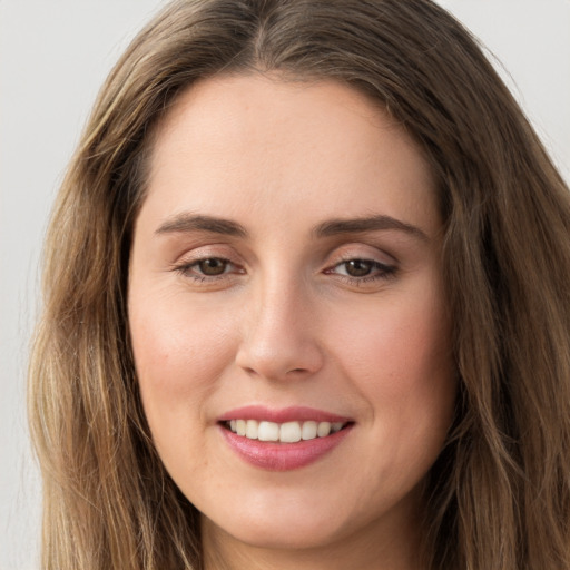 Joyful white young-adult female with long  brown hair and green eyes