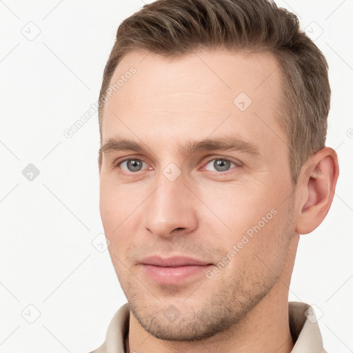 Joyful white young-adult male with short  brown hair and grey eyes