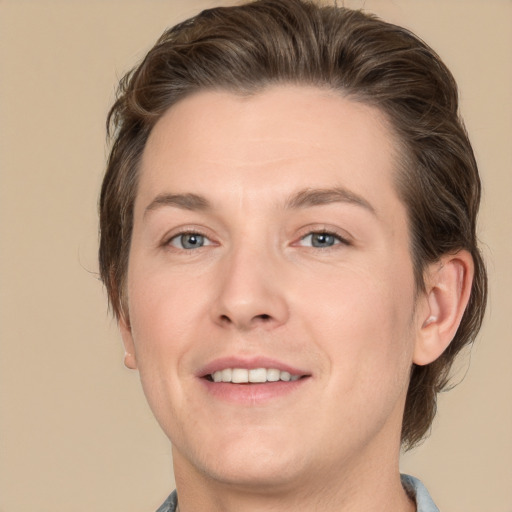 Joyful white young-adult male with medium  brown hair and grey eyes