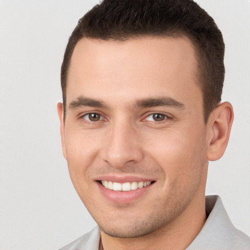 Joyful white young-adult male with short  brown hair and brown eyes