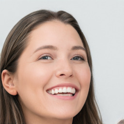 Joyful white young-adult female with long  brown hair and blue eyes