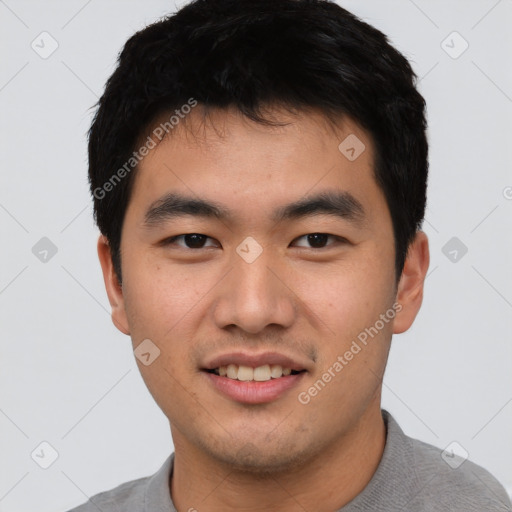 Joyful asian young-adult male with short  black hair and brown eyes