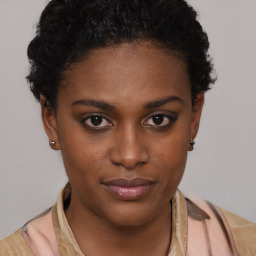 Joyful black young-adult female with short  brown hair and brown eyes