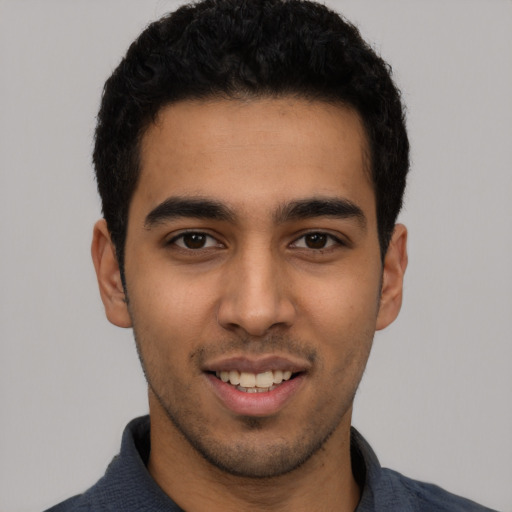 Joyful latino young-adult male with short  black hair and brown eyes