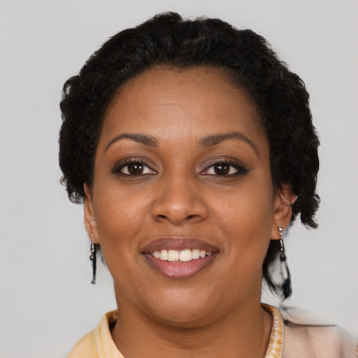 Joyful black adult female with short  brown hair and brown eyes
