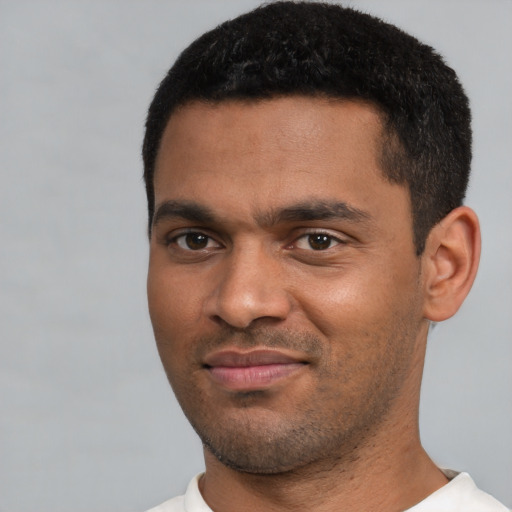 Joyful black young-adult male with short  black hair and brown eyes