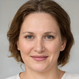 Joyful white adult female with medium  brown hair and grey eyes