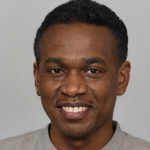 Joyful black young-adult male with short  black hair and brown eyes
