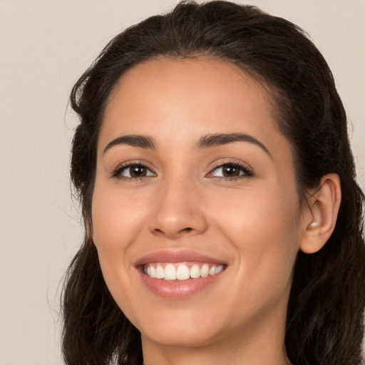 Joyful white young-adult female with long  brown hair and brown eyes