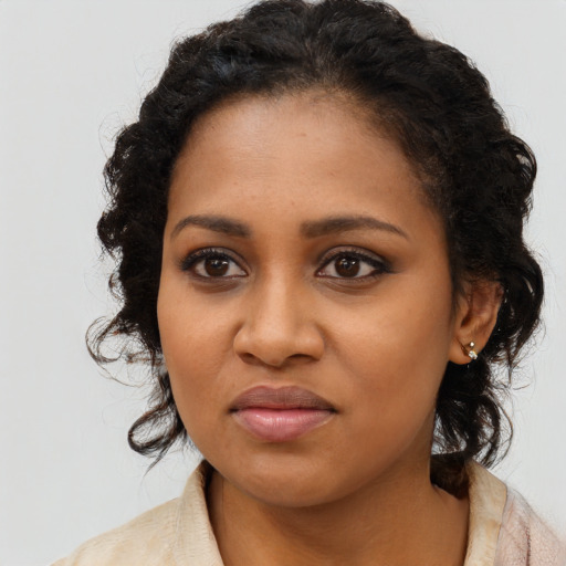 Joyful black young-adult female with long  black hair and brown eyes